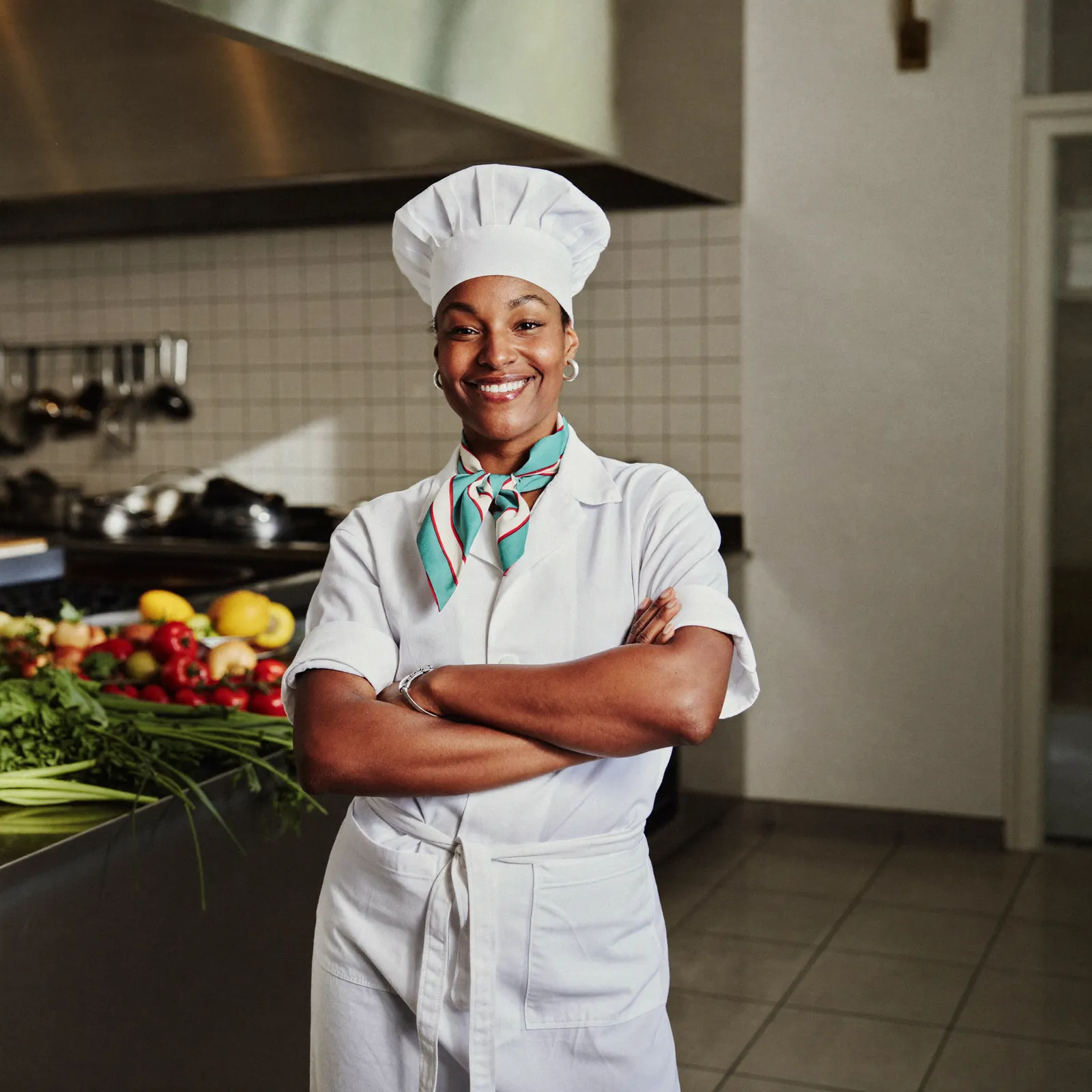 A proud restaurant owner in a bright daylight kitchen.